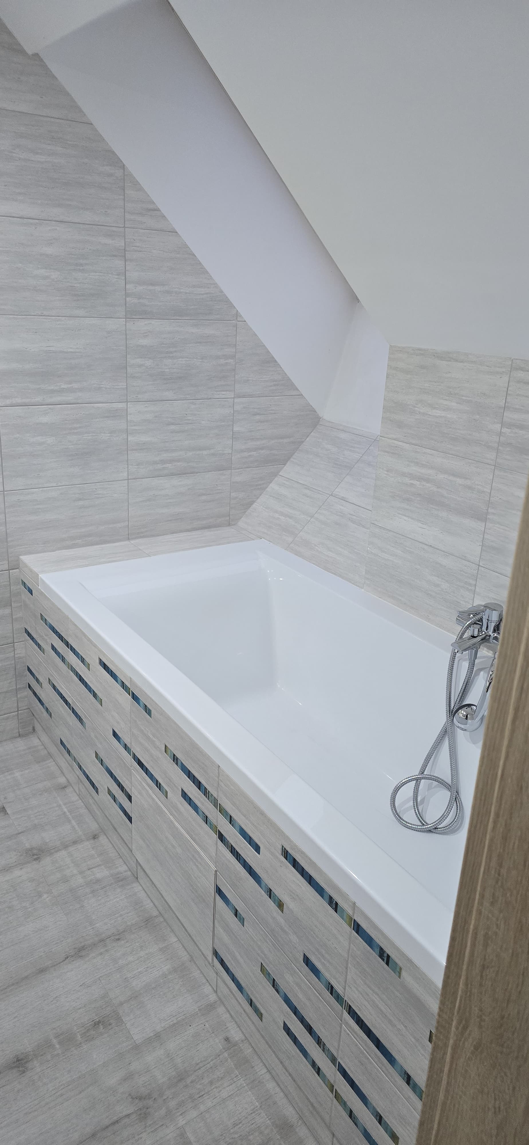 Łazienka z wanną i jasnymi płytkami